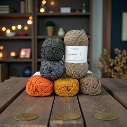 Stack of yarn balls with a label on a wooden surface, blurred indoor background