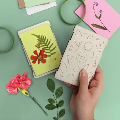 Patchwork with Busyfingers wooden flower press kit with dried red flower and fern on yellow card.