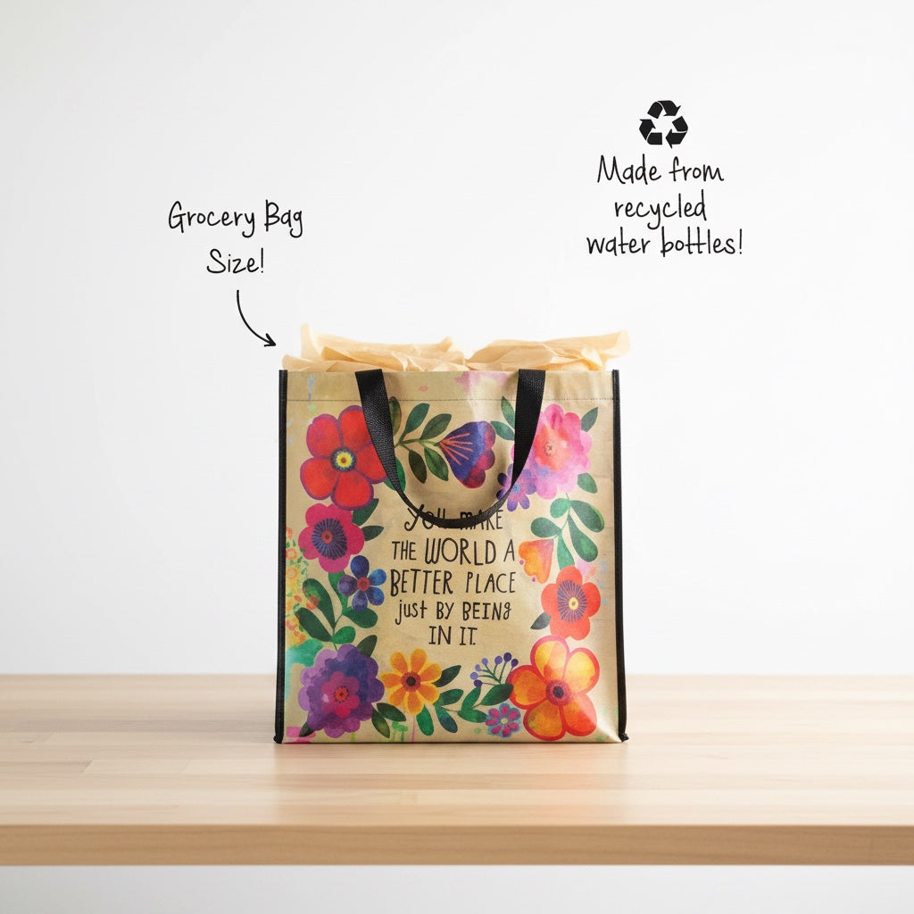 Patchwork with Busyfingers Happy Bag XL, a reusable grocery bag made from recycled water bottles, featuring a floral design and the quote "You make the world a better place just by being in it."