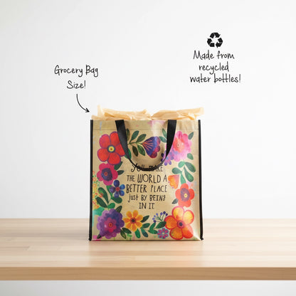 Patchwork with Busyfingers Happy Bag XL, a reusable grocery bag made from recycled water bottles, featuring a floral design and the quote "You make the world a better place just by being in it."