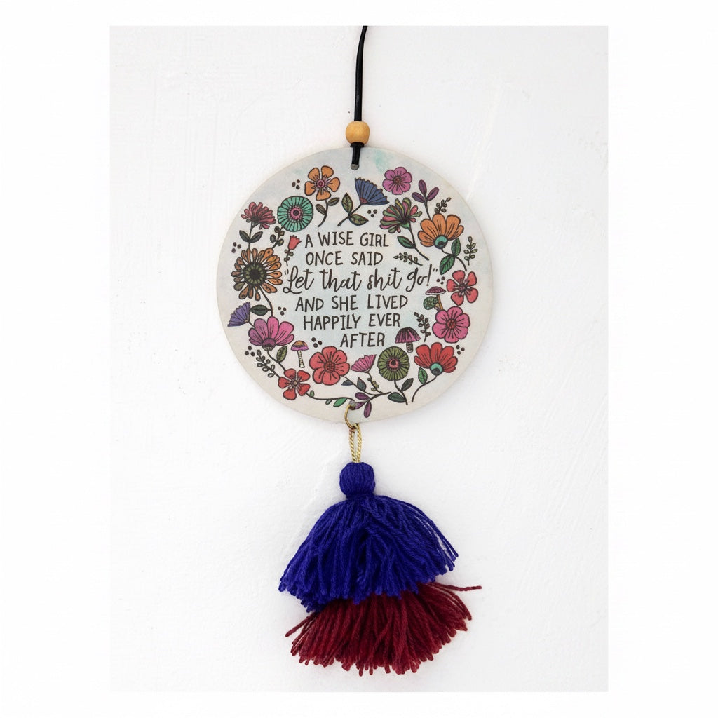 Patchwork with Busyfingers air freshener with floral design and quote "A wise girl once said let that shit go!" with blue and red tassels.
