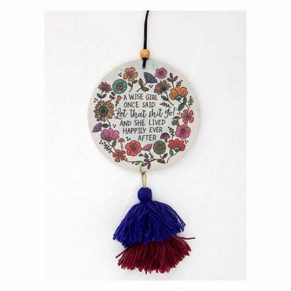 Patchwork with Busyfingers air freshener with floral design and quote "A wise girl once said let that shit go!" with blue and red tassels.