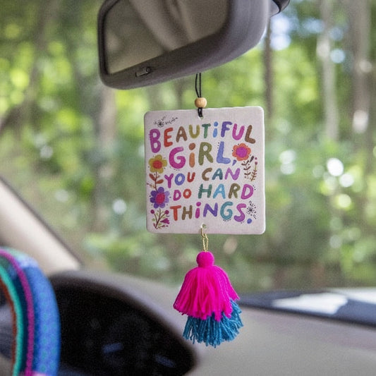 Patchwork with Busyfingers air freshener with colorful text 'Beautiful Girl, You Can Do Hard Things' and pink and blue tassels.