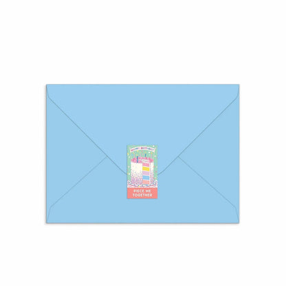 Patchwork with Busyfingers Confetti Birthday Cake greeting card puzzle on a light blue envelope, featuring a slice of cake with colourful layers and sprinkles.