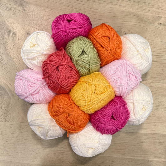 Patchwork with Busyfingers Blushing Stone wool yarn set in white, petal pink, lipstick pink, beige, musk green, rock grey, and stone.