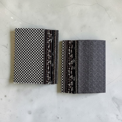 Patchwork with Busyfingers Classic Tuxedo 8-piece cotton fat eighth fabric pack with black and white floral prints.