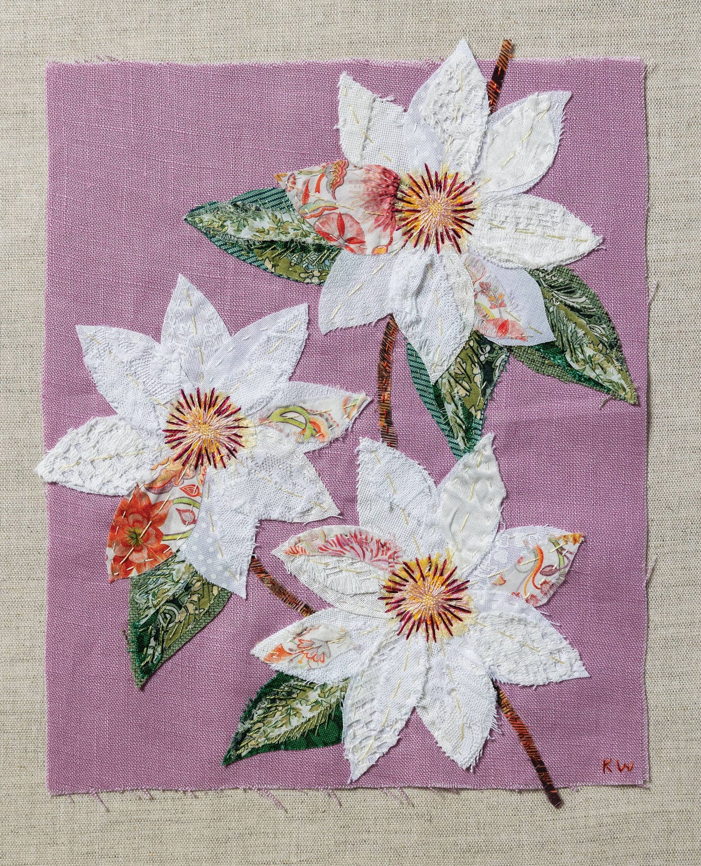 Patchwork with Busyfingers Clematis slow stitching kit featuring white fabric flowers on a pastel purple linen background