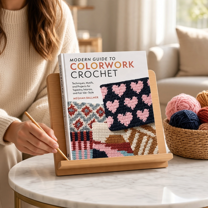 Patchwork with Busyfingers Modern Guide to Colorwork Crochet book on a wooden stand with yarn in a cozy room
