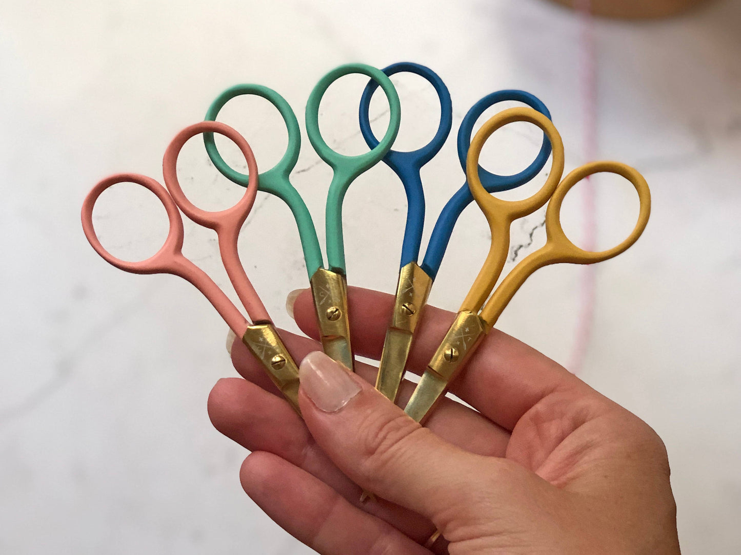 Patchwork with Busyfingers coloured embroidery scissors in mint, pink, blue, and yellow with gold finish blades.