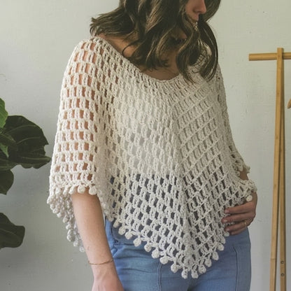 Model wearing a cream crochet poncho from the Patchwork with Busyfingers Crochet Layers to Love pattern book.