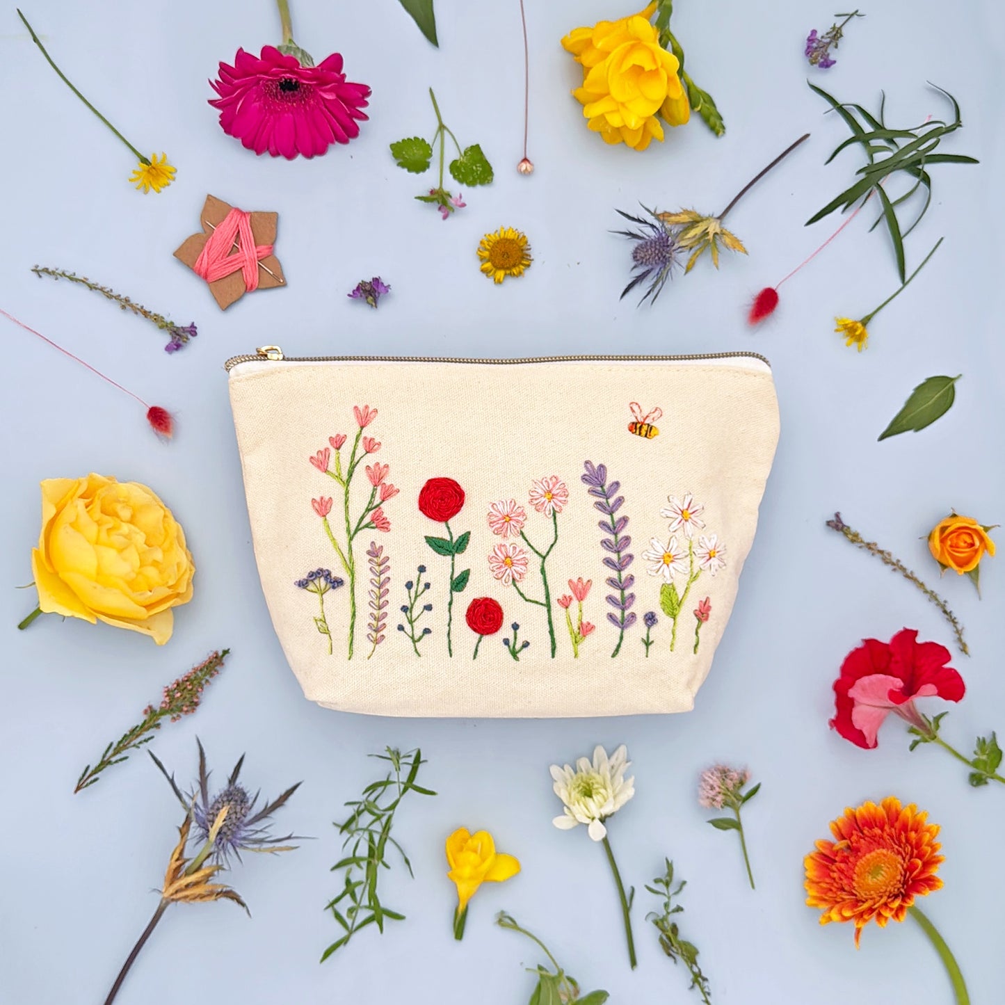 Patchwork with Busyfingers floral embroidery kit on a canvas zip pouch with a bee and meadow flowers design.
