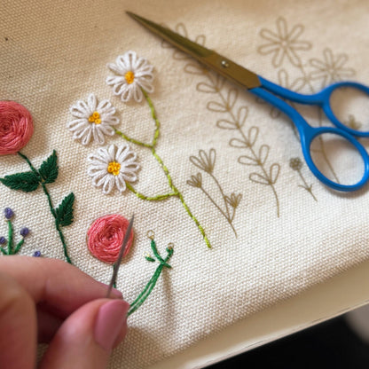 Patchwork with Busyfingers floral embroidery kit with pink roses and white daisies on canvas, includes scissors and needle.