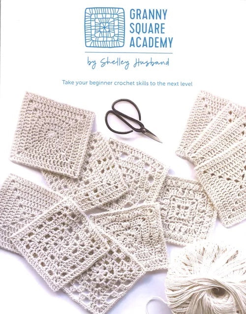 Patchwork with Busyfingers Granny Square Academy crochet book cover with white yarn squares and scissors