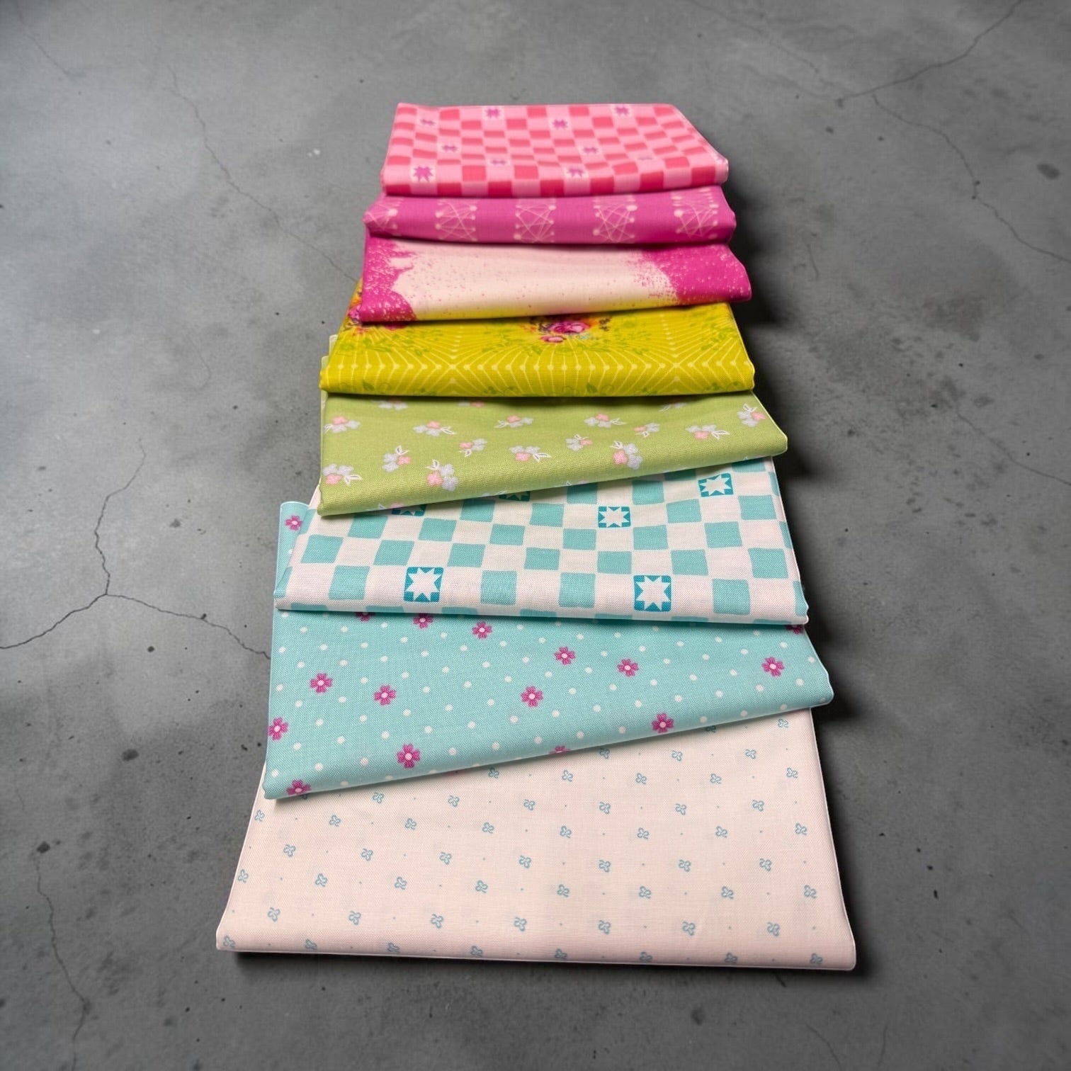 Patchwork with Busyfingers Juicy Burst 8pc fabric bundle featuring vibrant cotton prints in pink, yellow, and teal.