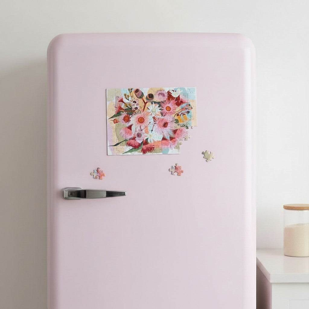 Patchwork with Busyfingers magnetic floral art 100-piece puzzle on a pink refrigerator, featuring a vibrant bouquet of pink and white Australian native flowers.