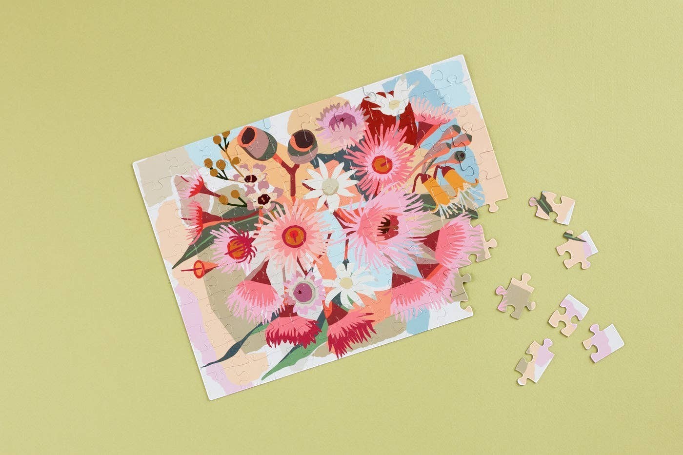 Patchwork with Busyfingers Magnetic Floral Art 100-piece puzzle featuring a vibrant bouquet of pink and white Australian native flowers and gum nuts.