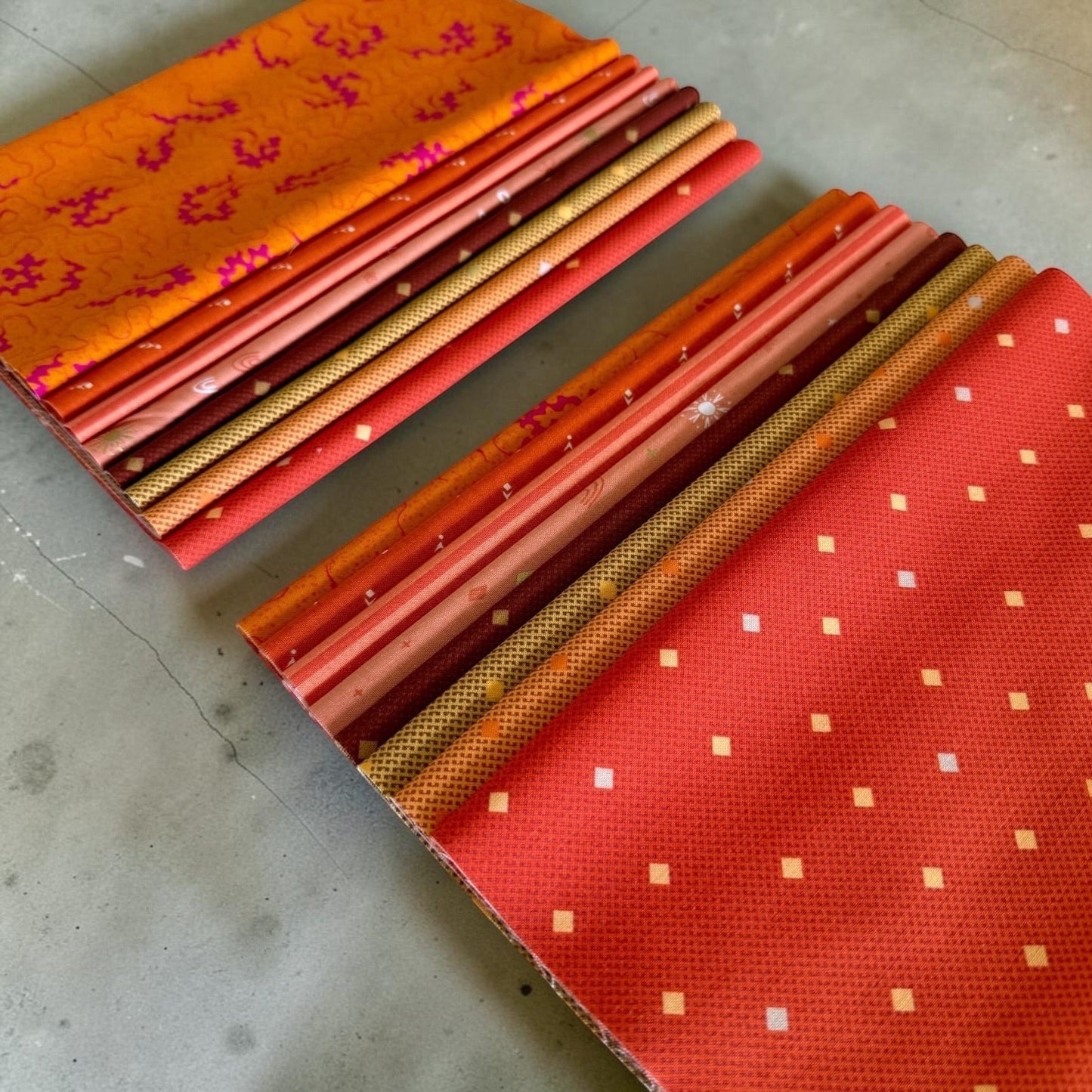 Patchwork with Busyfingers Marigold Spice 8-piece cotton fabric fat eighth pack in warm orange and red tones.