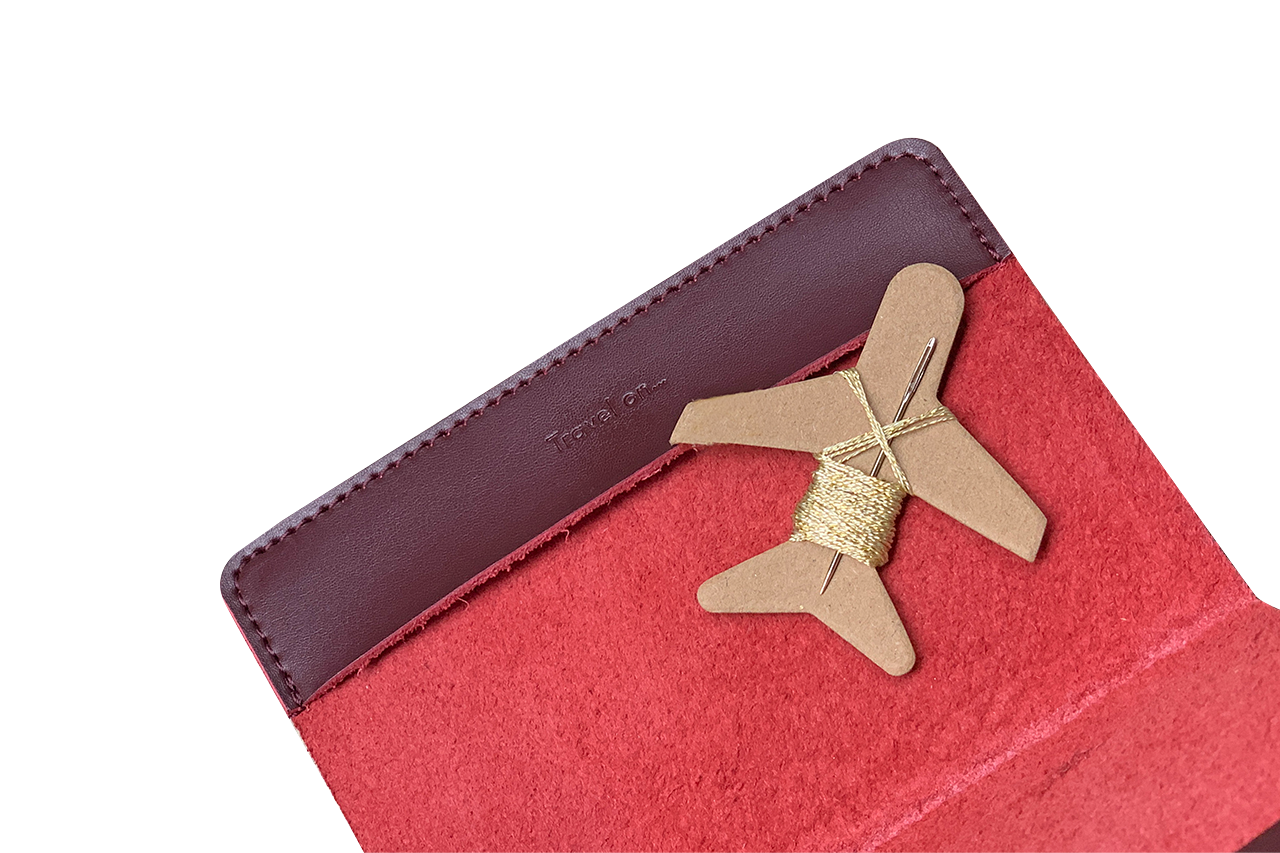 Patchwork with Busyfingers maroon leather passport cover kit with red suede interior and airplane-shaped embroidery floss holder.