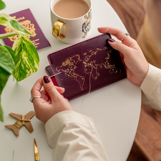 Patchwork with Busyfingers maroon leather passport cover kit with gold world map embroidery detail.