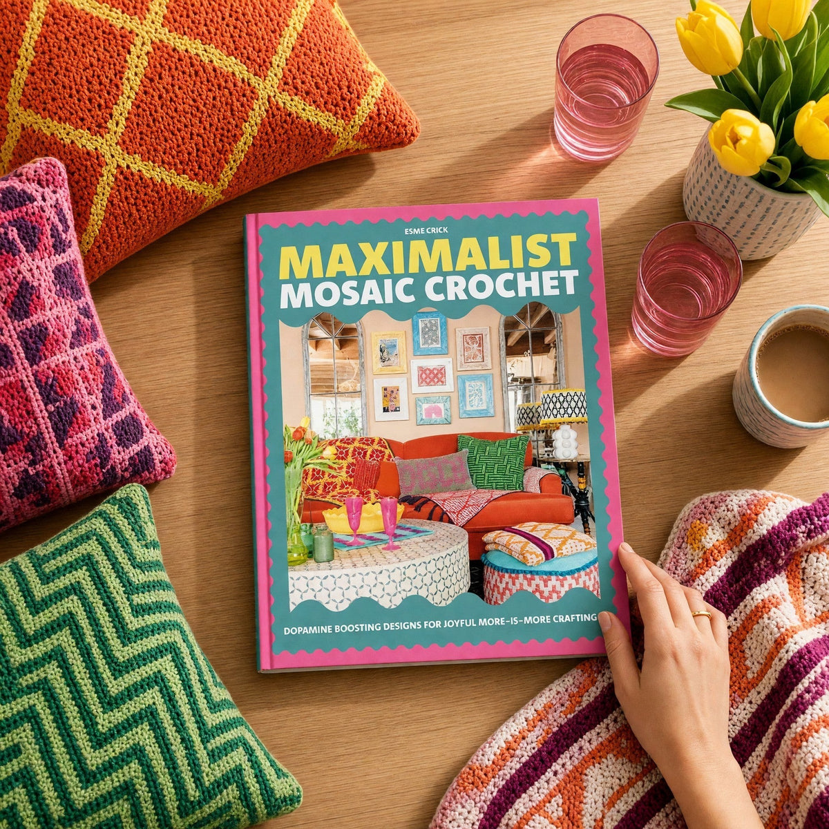 Patchwork with Busyfingers Maximalist Mosaic Crochet book surrounded by colourful handmade crochet pillows on a table