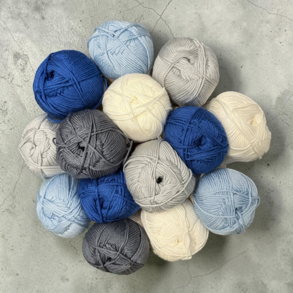 Patchwork with Busyfingers Mist & Minerals yarn set in white, duck egg blue, steel blue, and marled grey. 100% anti-pilling acrylic yarn.