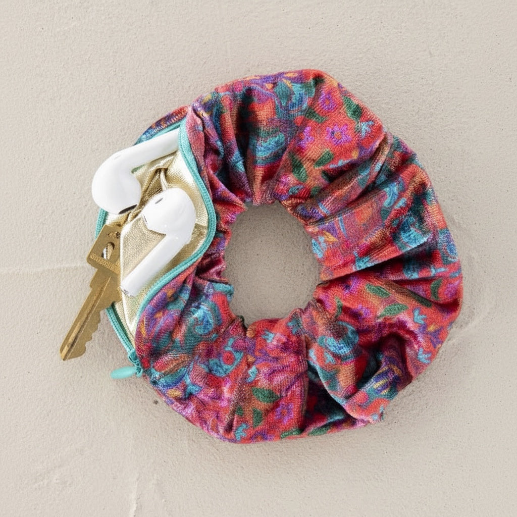 Patchwork with Busyfingers pink floral velvet scrunchie with hidden zipper compartment holding earbuds and a key.