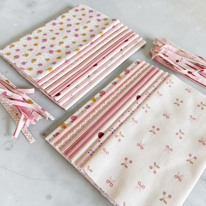 Patchwork with Busyfingers Powder Puff cotton fabric fat eighth pack with 8 assorted pink and white floral prints.