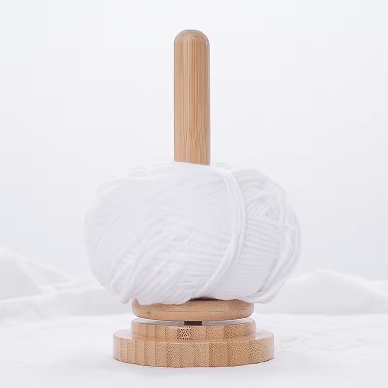 Patchwork with Busyfingers natural timber rotating yarn butler holding a ball of white yarn for knitting and crochet.