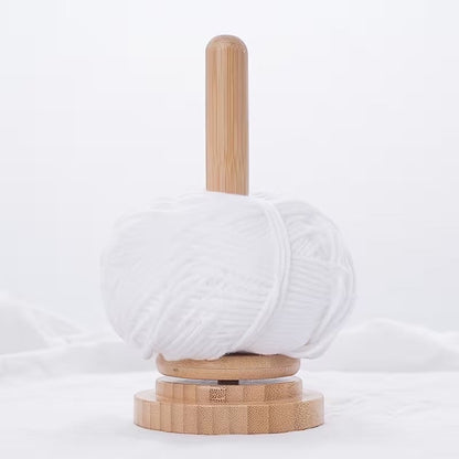 Patchwork with Busyfingers natural timber rotating yarn butler holding a ball of white yarn for knitting and crochet.