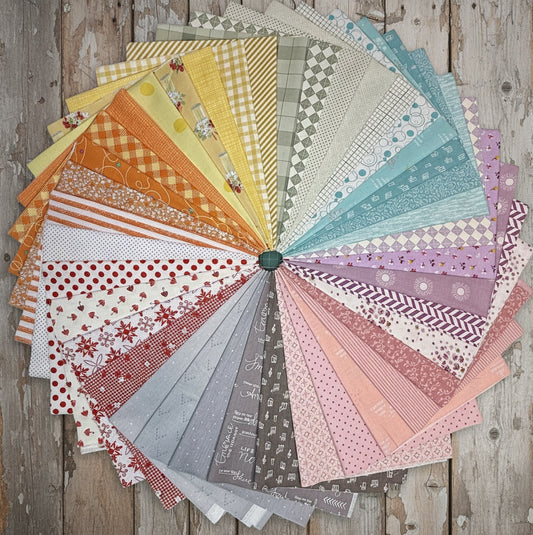 Patchwork with Busyfingers Sherbet Skies 40-piece cotton fat quarter bundle in a rainbow fan of soft pastel fabrics.