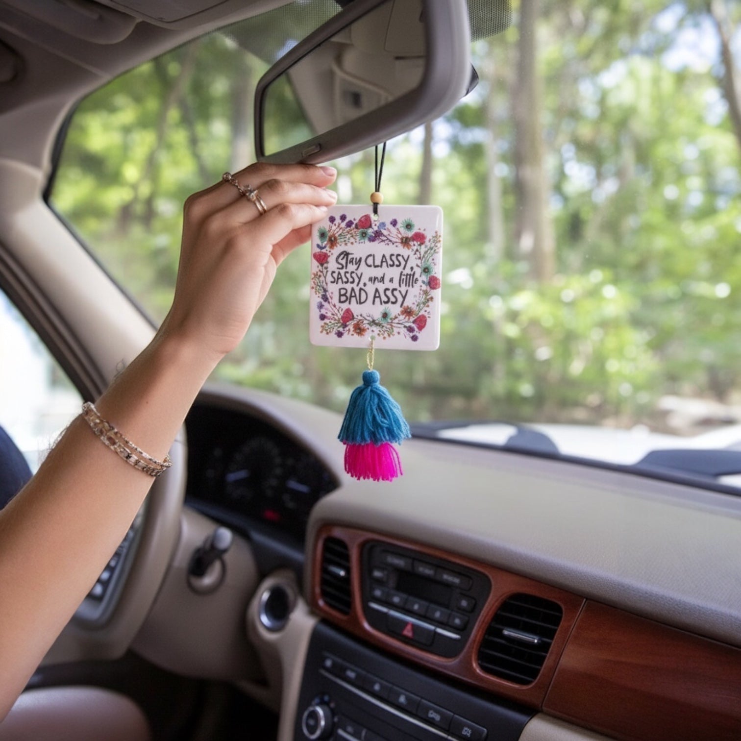 Patchwork with Busyfingers square air freshener with floral border and text 'Stay Classy Sassy, and a little BAD ASSY'. Features blue and pink tassels.