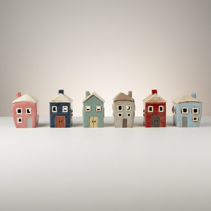 Patchwork with Busyfingers Grand Village Estate ceramic houses set in pink, blue, grey, and red with artisanal glazes.