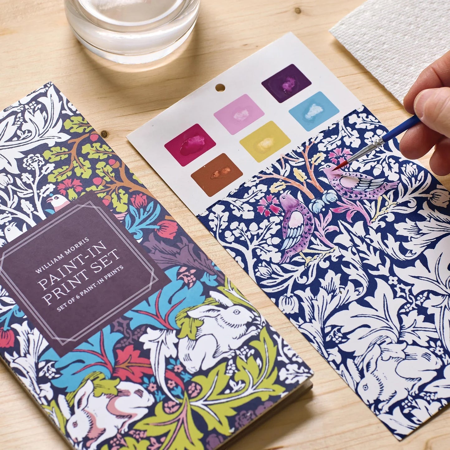 Patchwork with Busyfingers William Morris Paint-in Print Set featuring a paint palette with 6 colours and a brush painting a bird on patterned paper.