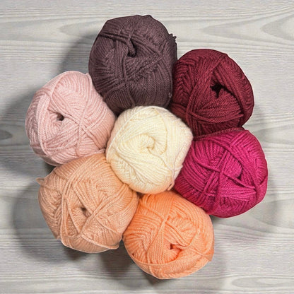 Patchwork with Busyfingers yarn set in shades of pink, cream, peach, coral, plum, and burgundy for The Hidden Stitch Blanket CAL.