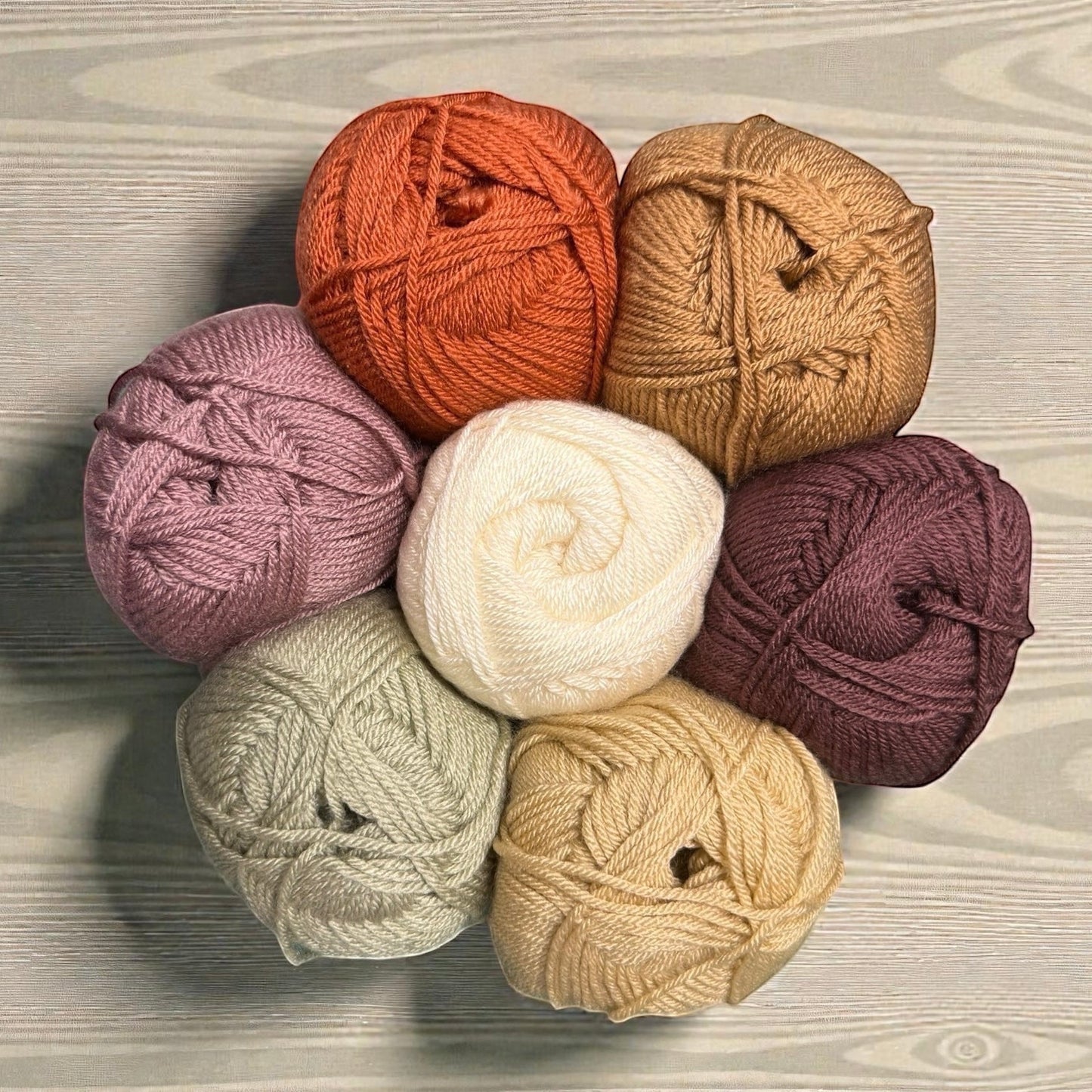 Patchwork with Busyfingers yarn set for The Hidden Stitch Blanket CAL Subscription. Includes balls of yarn in cream, rust orange, mauve, sage green, tan, and plum.