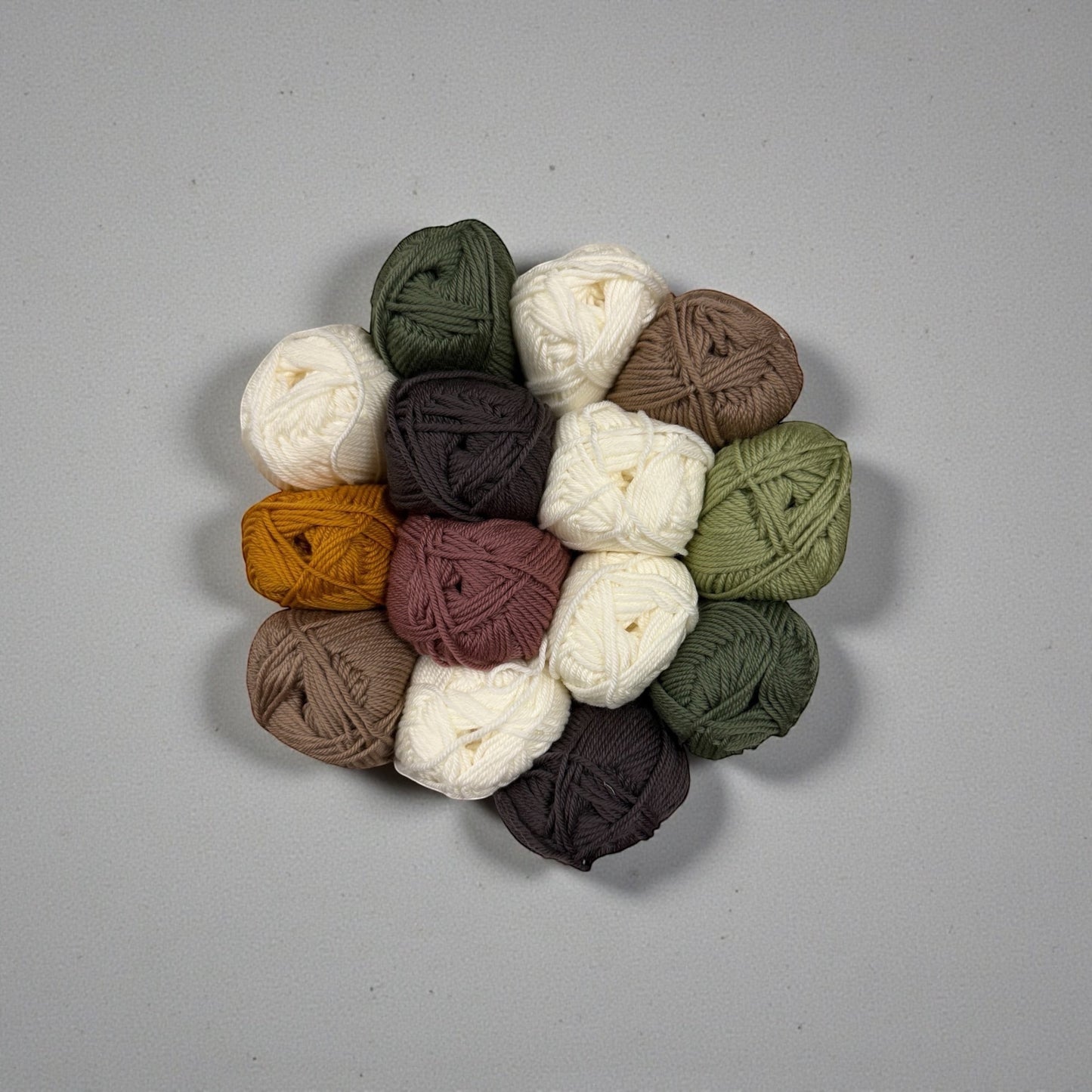Patchwork with Busyfingers yarn set for The Hidden Stitch Blanket CAL Subscription. Includes balls of yarn in cream, dark brown, olive green, rust, and taupe.