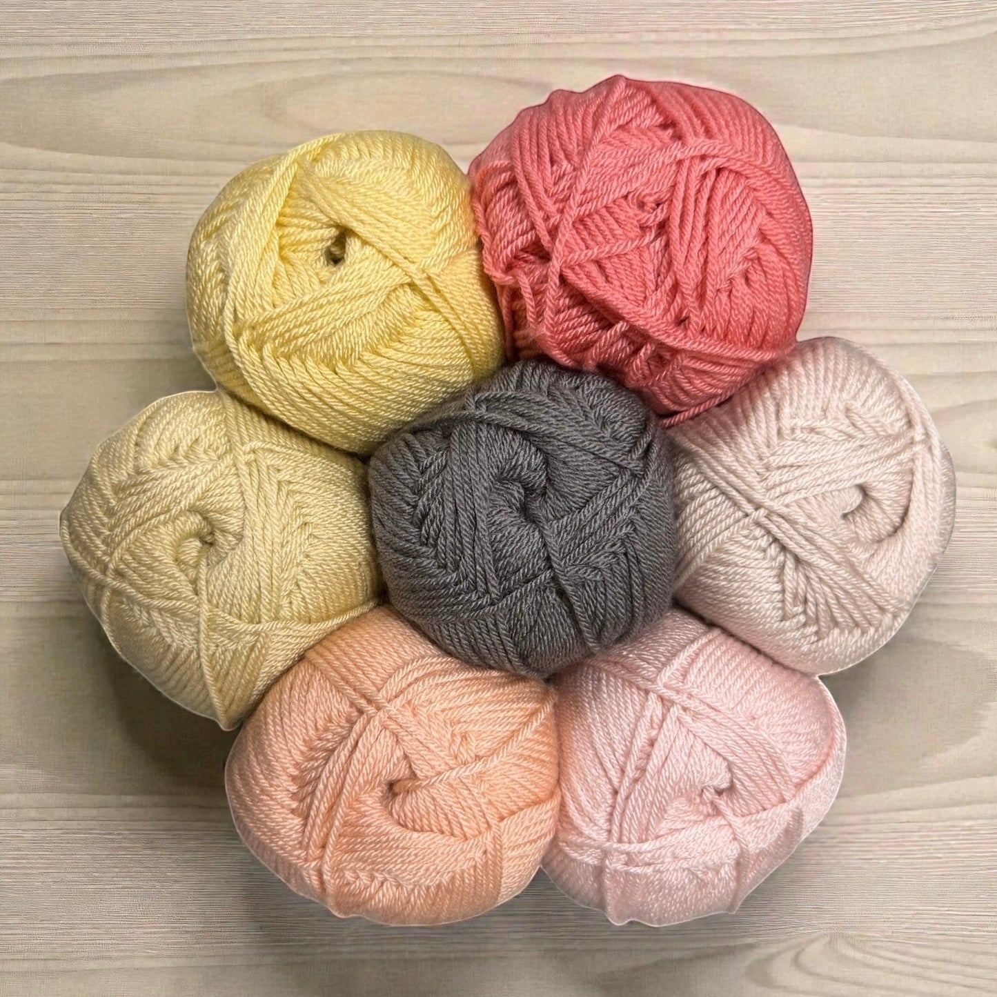 Patchwork with Busyfingers yarn set for Hidden Stitch Blanket CAL: pastel yellow, grey, pink, peach, and cream.