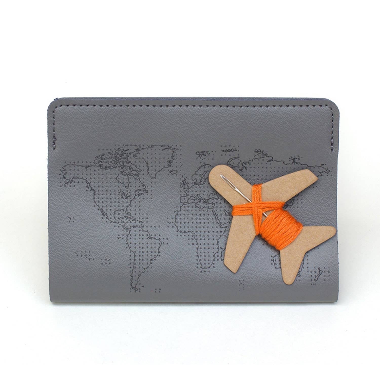 Patchwork with Busyfingers grey faux leather passport holder with world map design and airplane spool with orange thread.