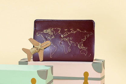 Patchwork with Busyfingers maroon leather passport cover kit with gold world map embroidery and airplane detail.