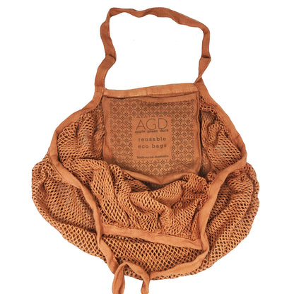 Patchwork with Busyfingers rust 100% cotton crescent net bag with long handles and a small pouch inside.